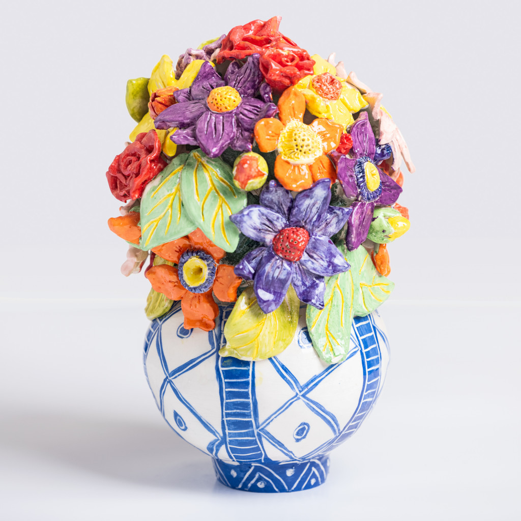 Ceramic still life of a vase with branch with colorful flowers, handmade and painted in a unique & colourful style by Spanish artist Maite Morell.