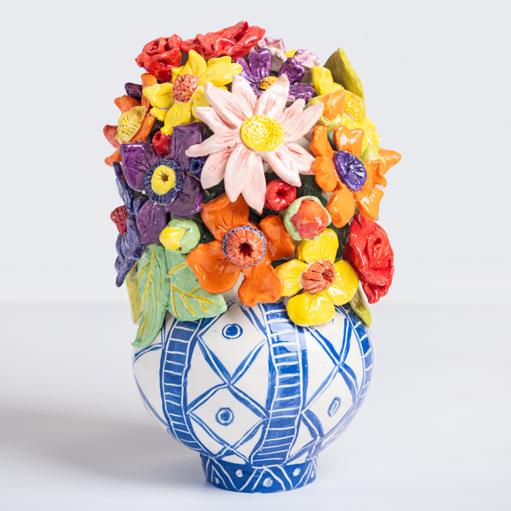 Ceramic still life of a vase with branch with colorful flowers, handmade and painted in a unique & colourful style by Spanish artist Maite Morell.