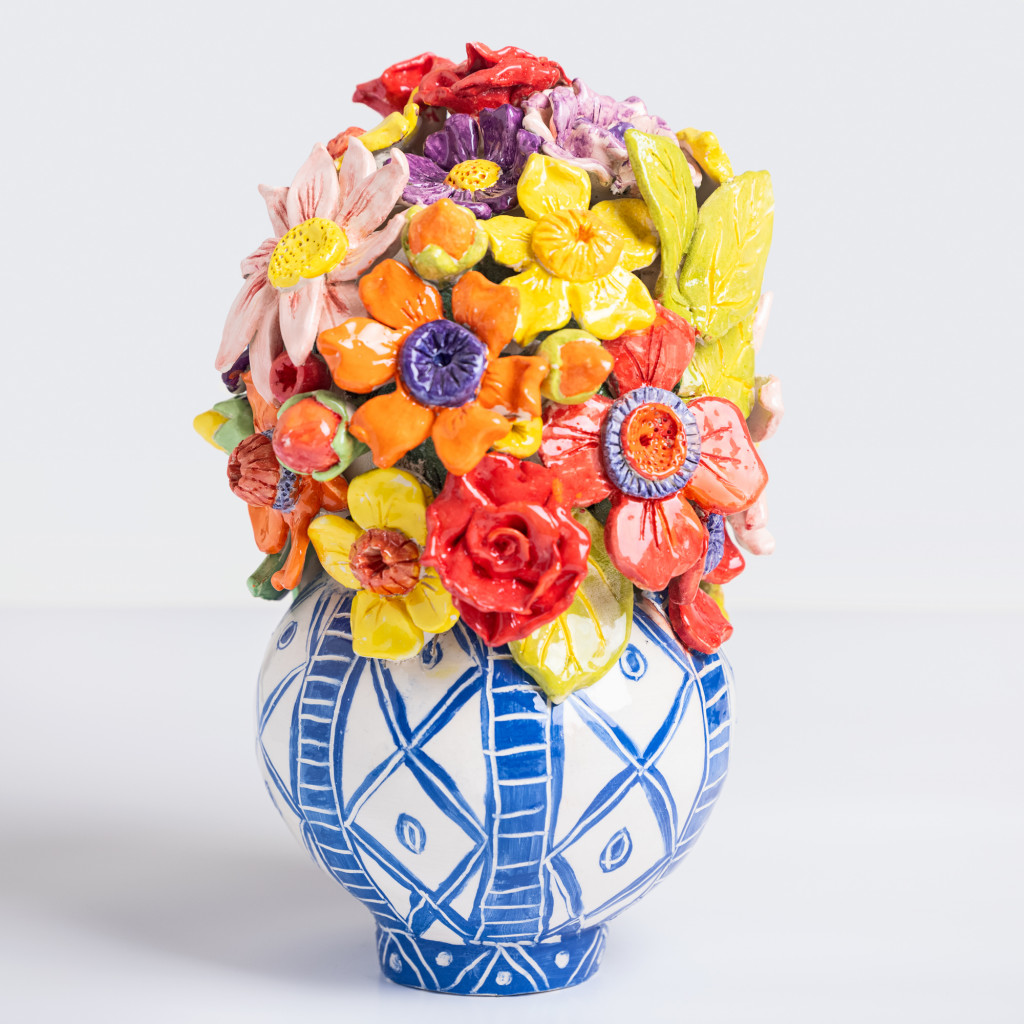 Ceramic still life of a vase with branch with colorful flowers, handmade and painted in a unique & colourful style by Spanish artist Maite Morell.