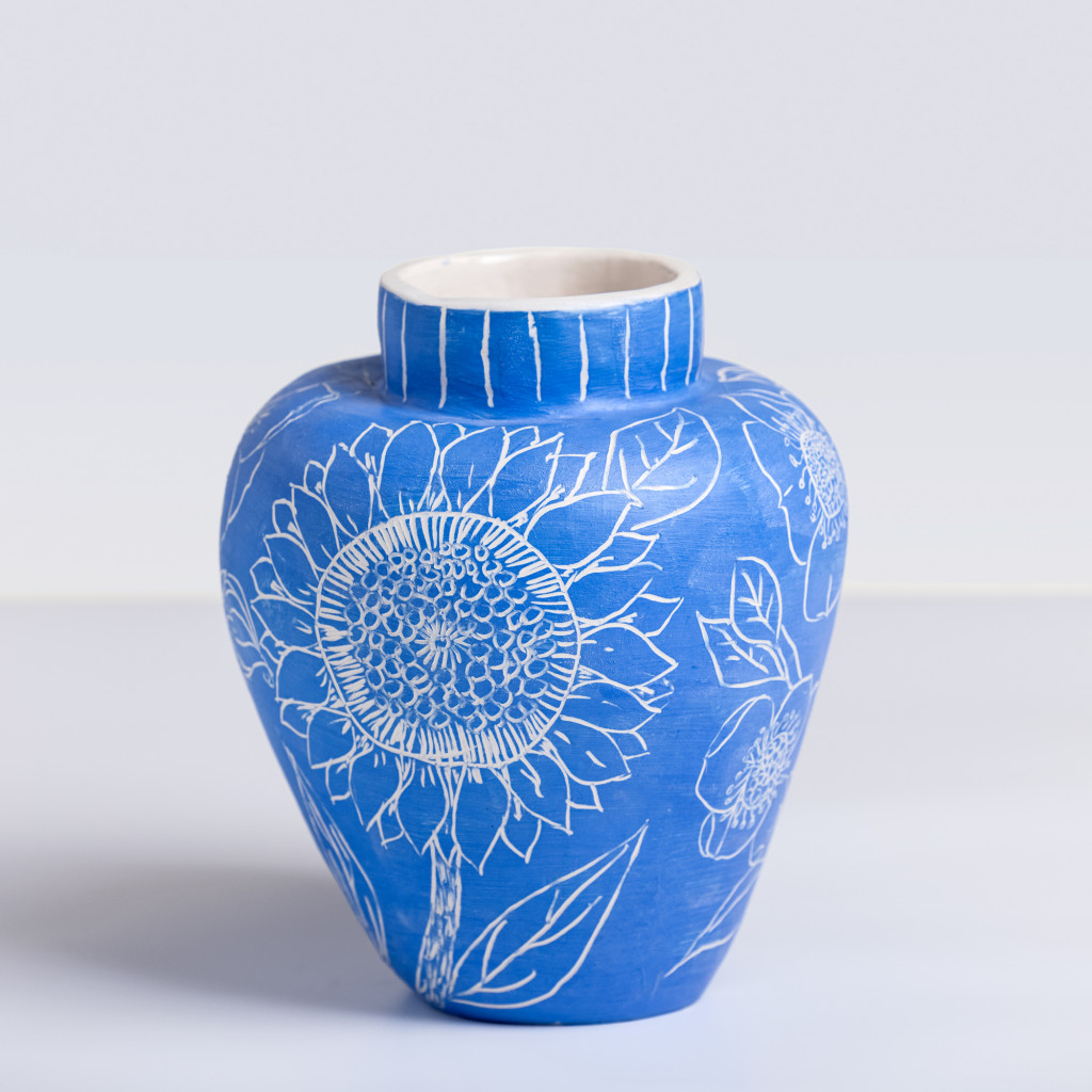 Ceramic vase with white flowers on matte klein blue background, handmade and painted in a unique style by Spanish artist Maite Morell.