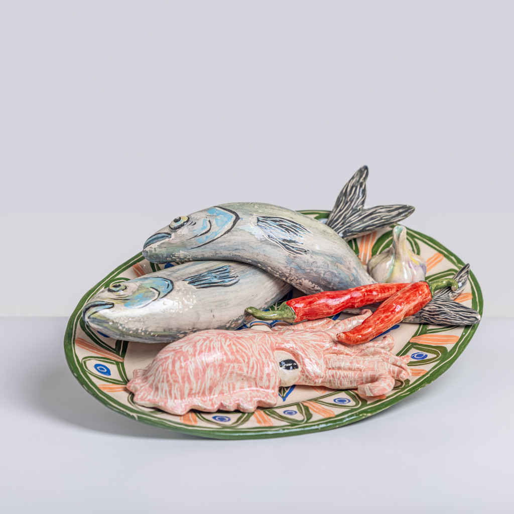 Ceramic still life with sea bass, cuttlefish, chili and a head of garlic, handmade and painted in a unique & colourful style by Spanish artist Maite Morell.