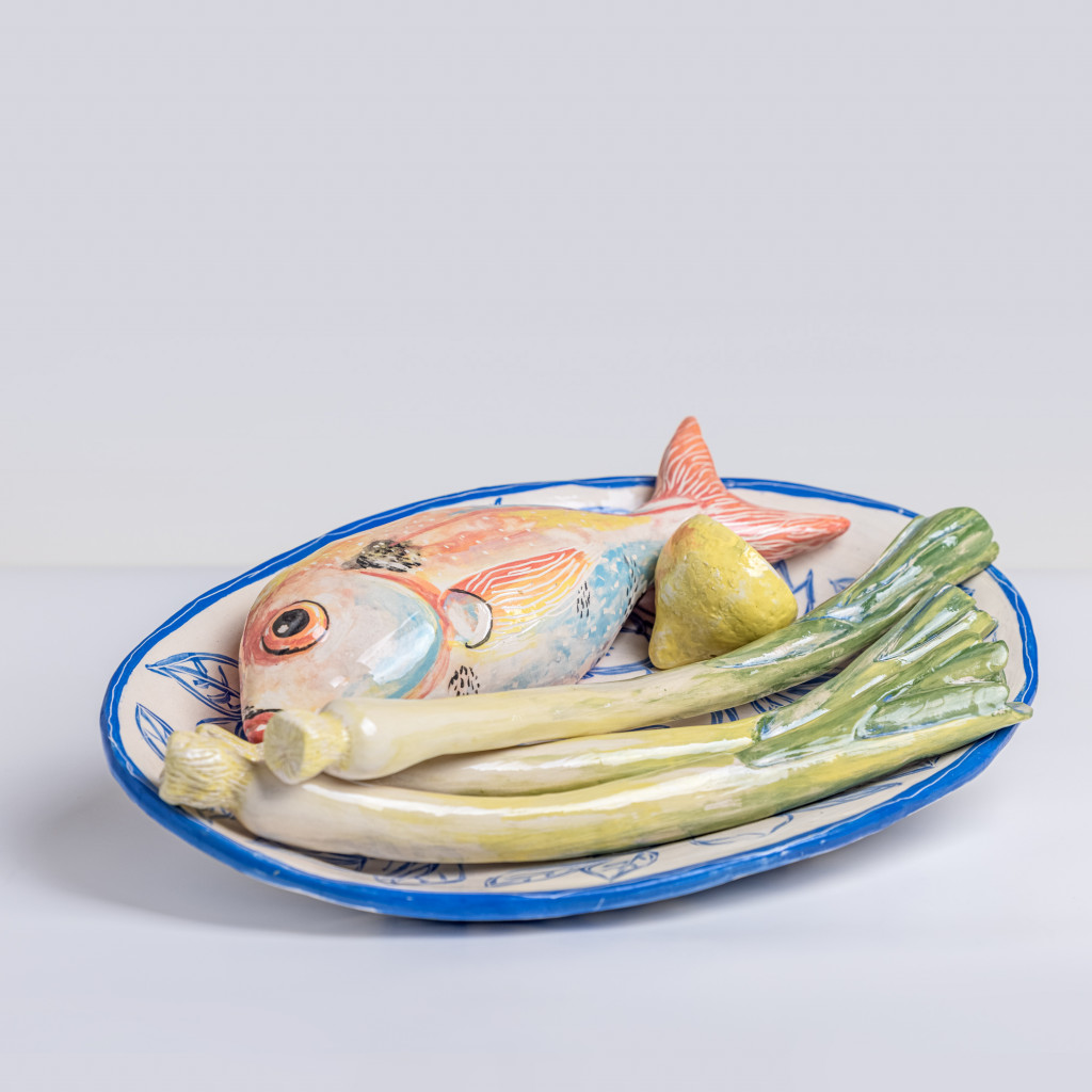 Ceramic still life with sea bream, leeks and half a lemon, handmade and painted in a unique & colourful style by Spanish artist Maite Morell.