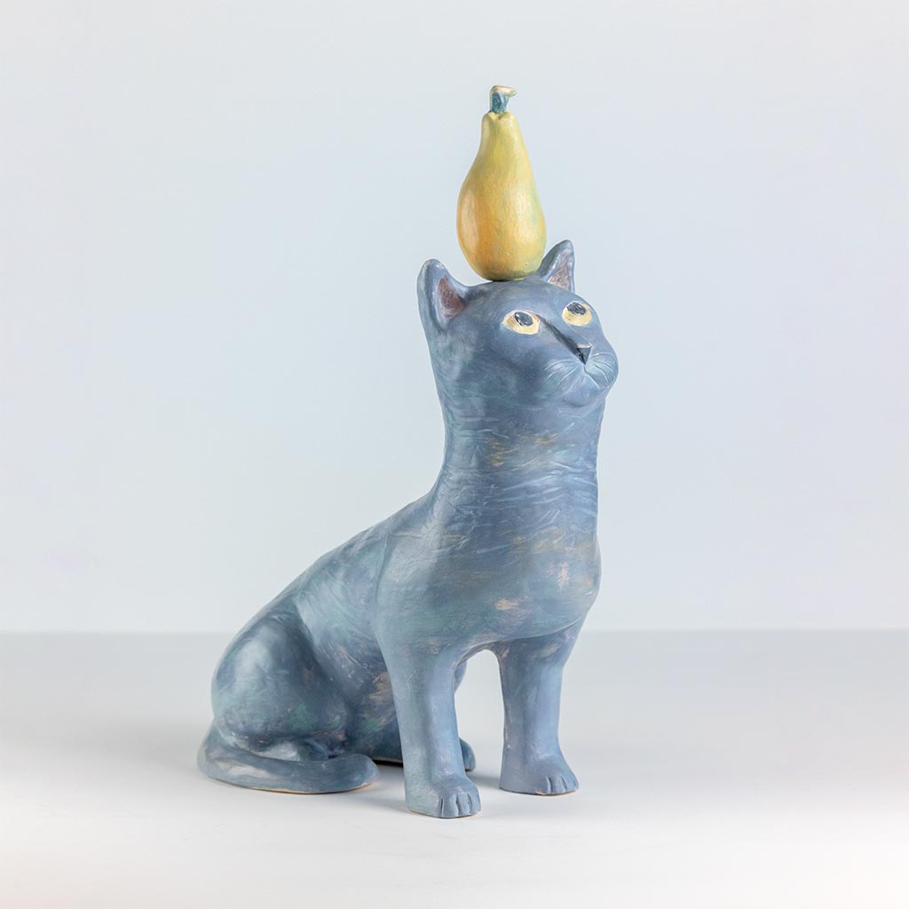 Ceramic sculpture of a cat with a pear, handmade and painted in a unique style by Spanish artist Maite Morell.