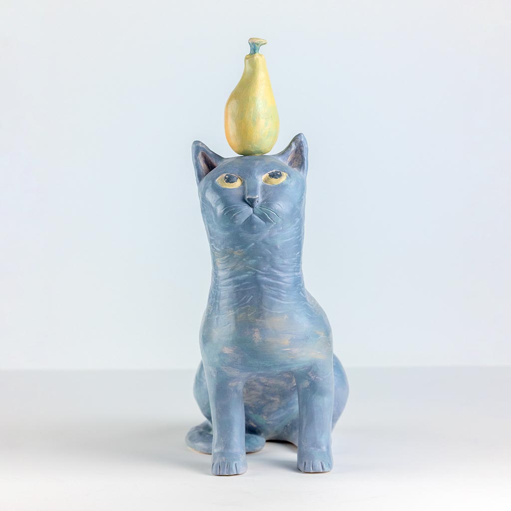 Ceramic sculpture of a cat with a pear, handmade and painted in a unique style by Spanish artist Maite Morell.