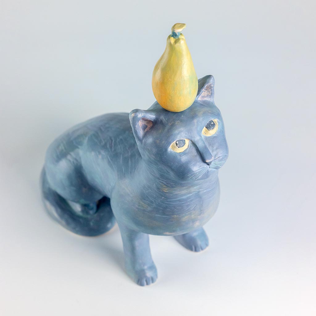 Ceramic sculpture of a cat with a pear, handmade and painted in a unique style by Spanish artist Maite Morell.