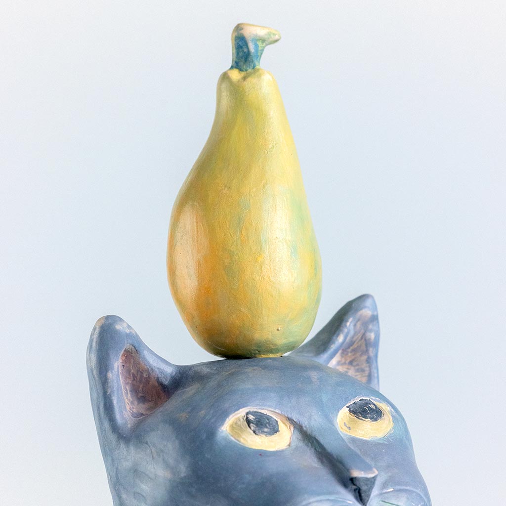 Ceramic sculpture of a cat with a pear, handmade and painted in a unique style by Spanish artist Maite Morell.