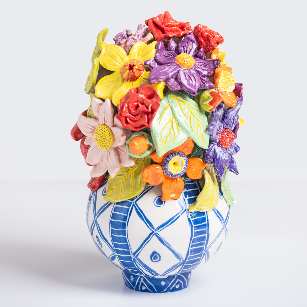 Ceramic still life of a vase with branch with colorful flowers, handmade and painted in a unique & colourful style by Spanish artist Maite Morell.