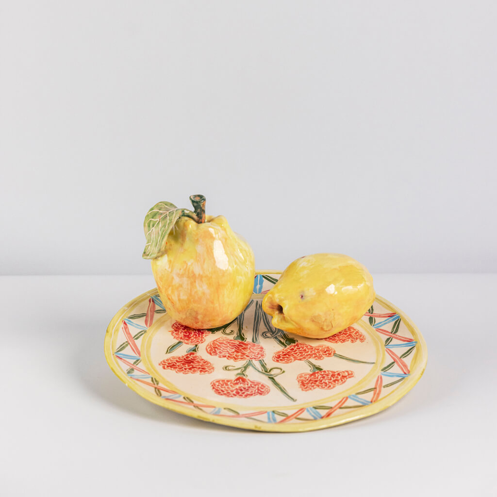 Ceramic still life of a plate of carnations and two quinces, handmade and painted in a unique & colourful style by Spanish artist Maite Morell.