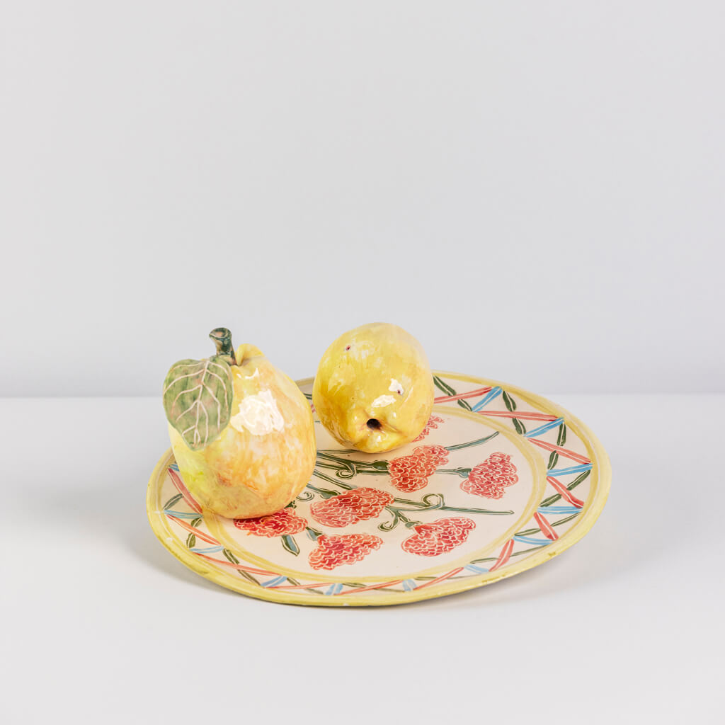 Ceramic still life of a plate of carnations and two quinces, handmade and painted in a unique & colourful style by Spanish artist Maite Morell.