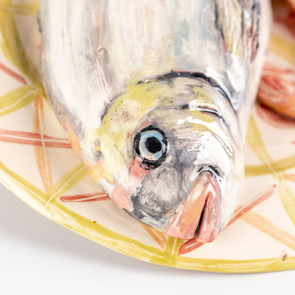 Ceramic still life of a plate of fish, prawns and lemon, handmade and painted in a unique & colourful style by Spanish artist Maite Morell.