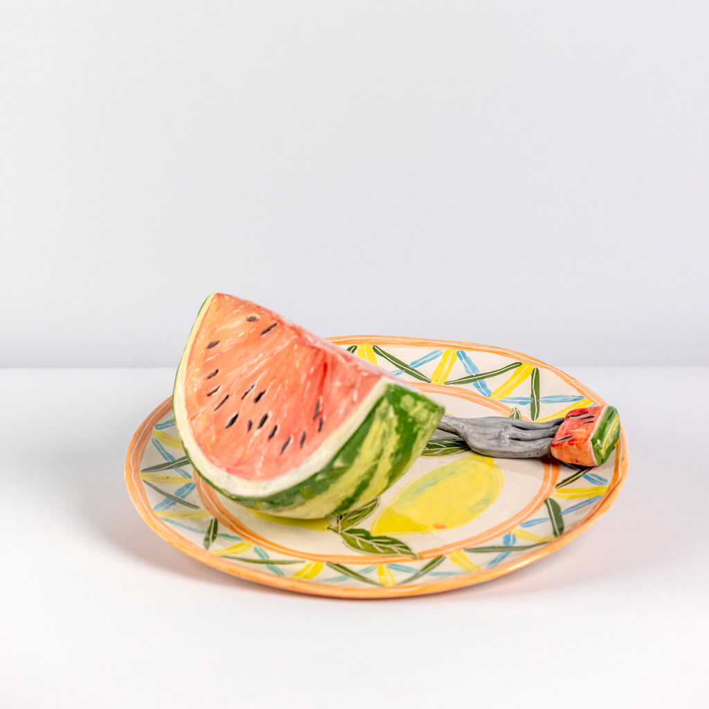 Ceramic still life of a plate of watermelon and a fork, handmade and painted in a unique & colourful style by Spanish artist Maite Morell.