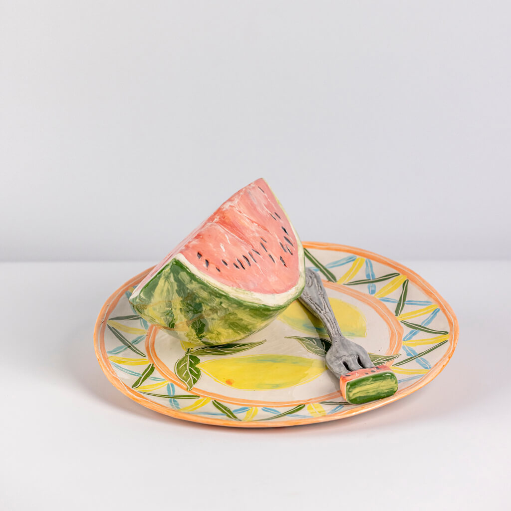 Ceramic still life of a plate of watermelon and a fork, handmade and painted in a unique & colourful style by Spanish artist Maite Morell.