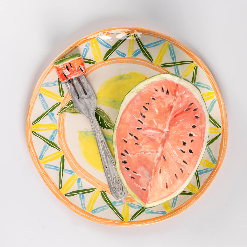 Ceramic still life of a plate of watermelon and a fork, handmade and painted in a unique & colourful style by Spanish artist Maite Morell.