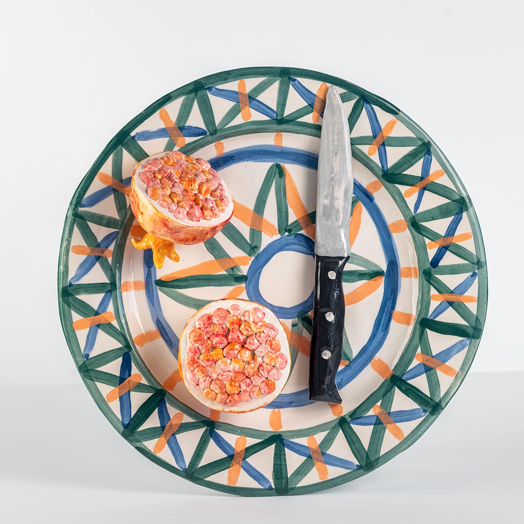 Ceramic still life with pomegranate and knife, handmade and painted in a unique style by Spanish artist Maite Morell.