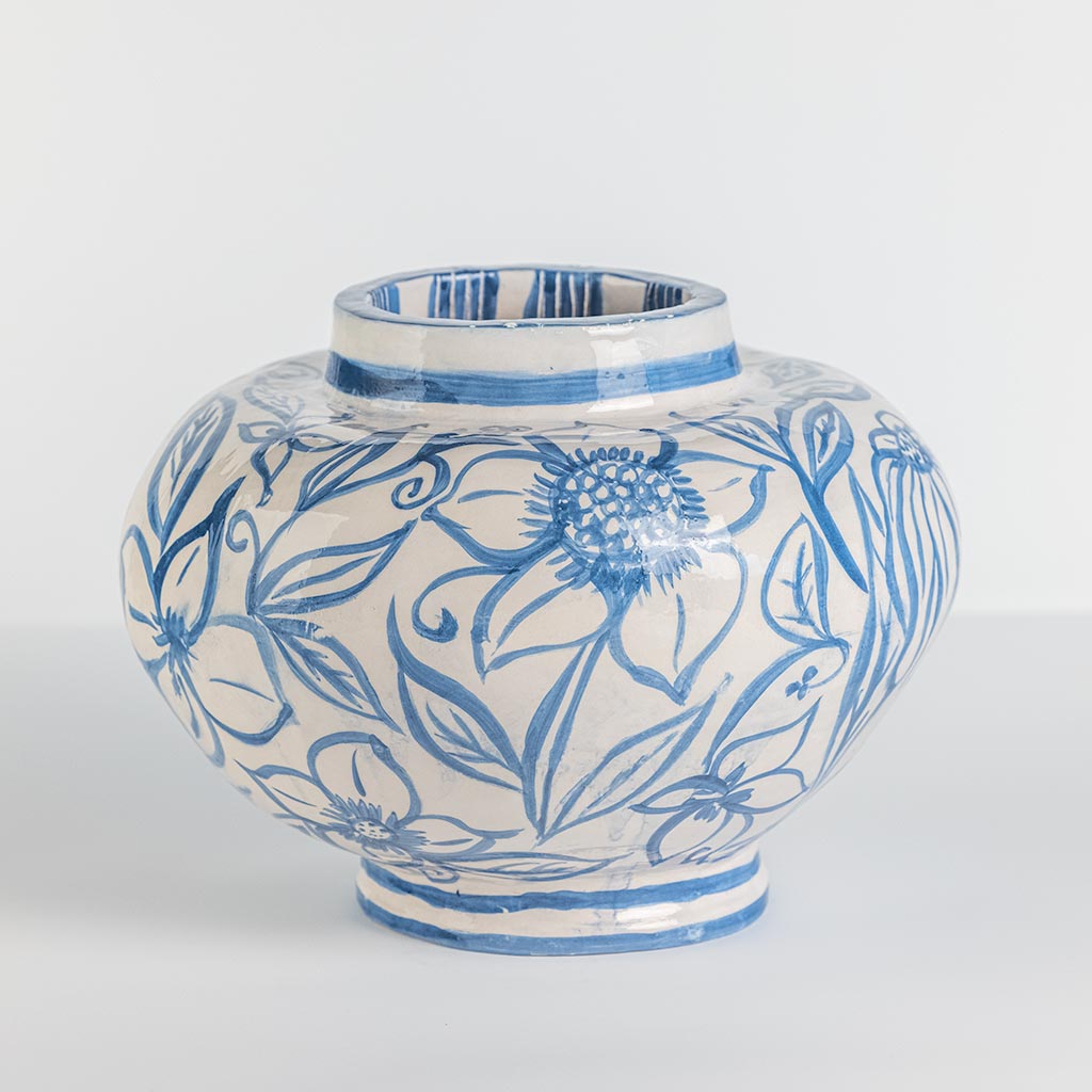 Ceramic vase with blue flowers on white background, handmade and painted in a unique style by Spanish artist Maite Morell.