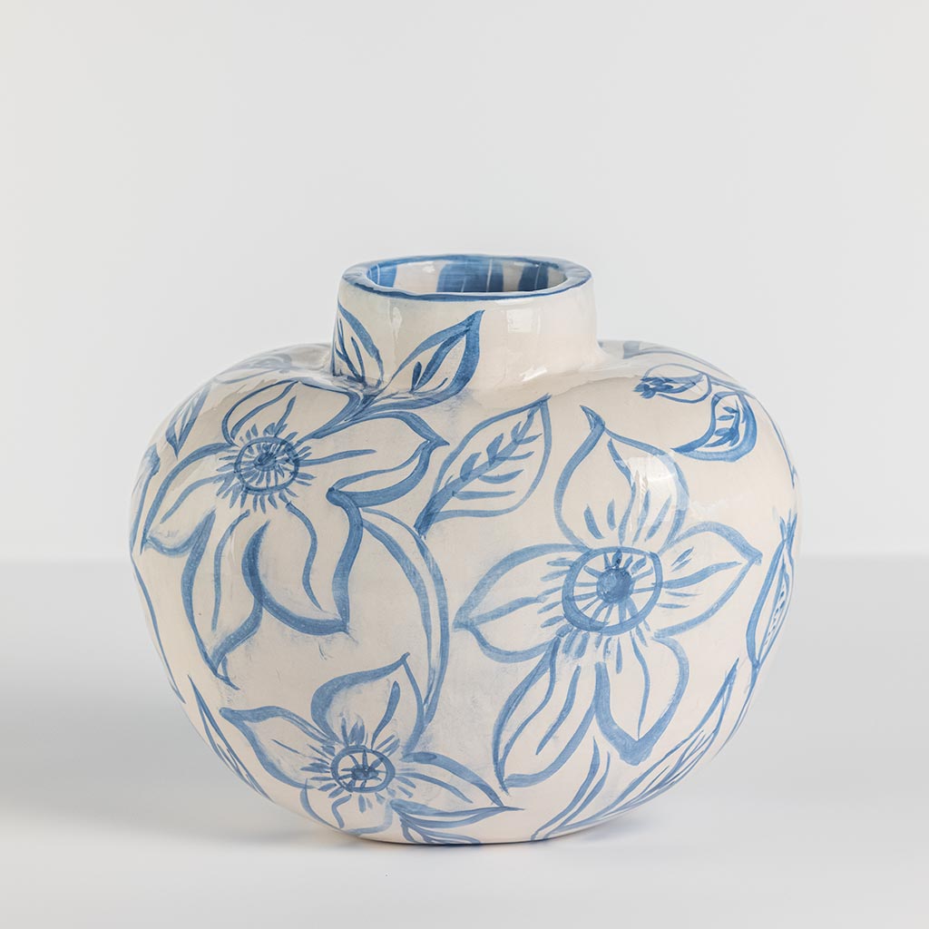 Ceramic oval vase with blue flowers on white background, handmade and painted in a unique style by Spanish artist Maite Morell.