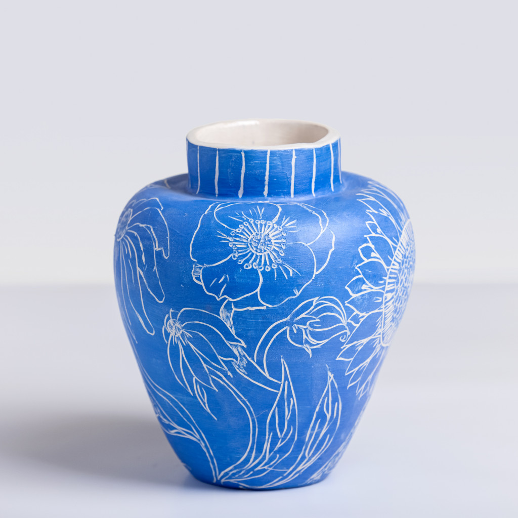Ceramic vase with white flowers on matte klein blue background, handmade and painted in a unique style by Spanish artist Maite Morell.