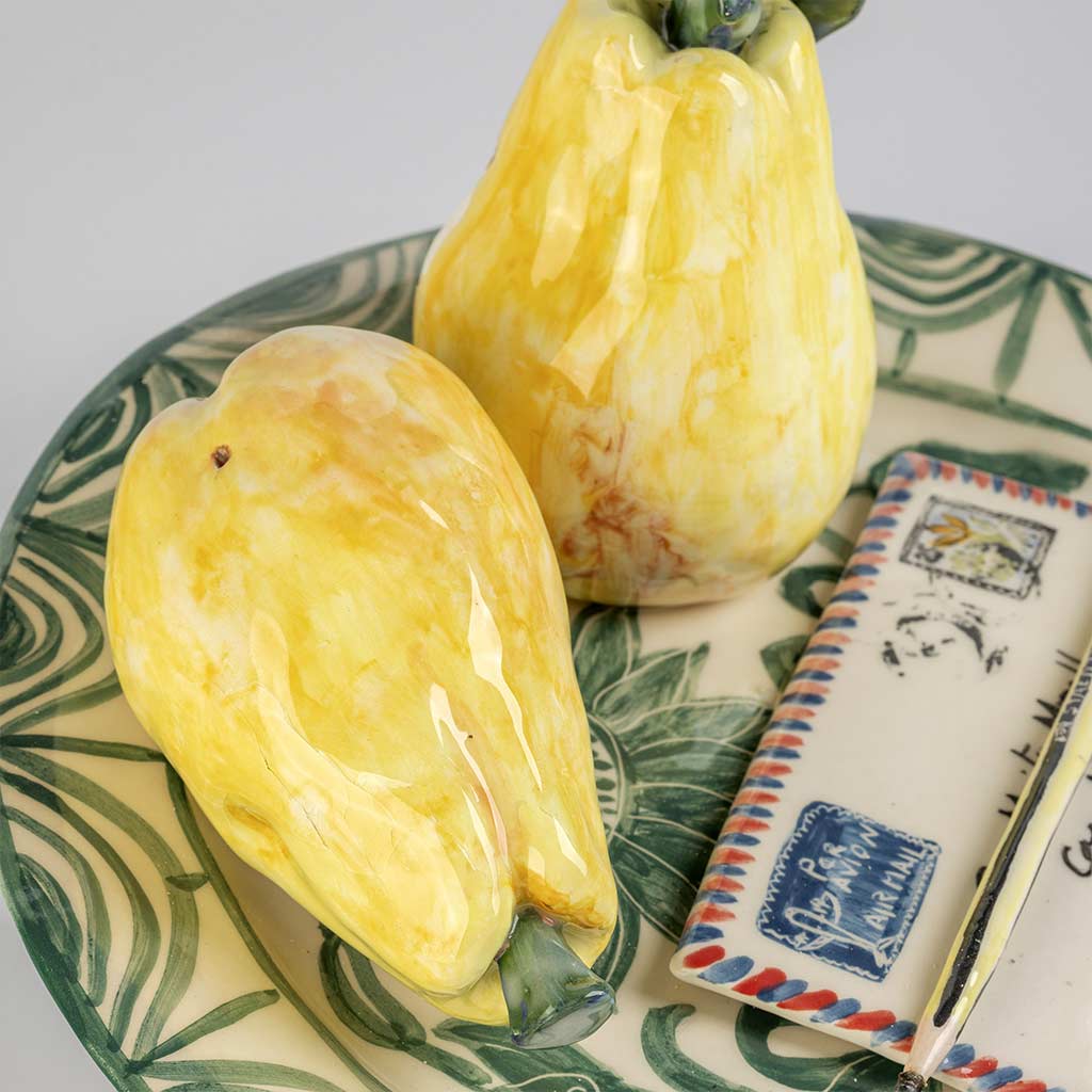 Ceramic still life of a green plate with a quince and a love letter, handmade and painted in a unique style by Spanish artist Maite Morell.