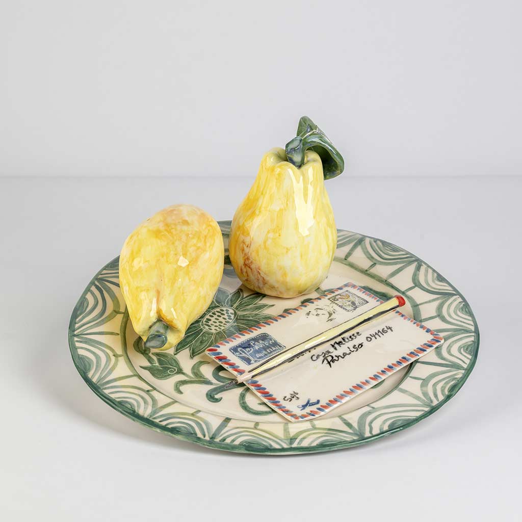 Ceramic still life of a green plate with a quince and a love letter, handmade and painted in a unique style by Spanish artist Maite Morell.