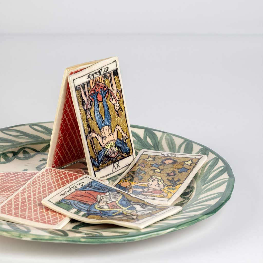Ceramic still life of a green plate with tarot cards, handmade and painted in a unique style by Spanish artist Maite Morell.