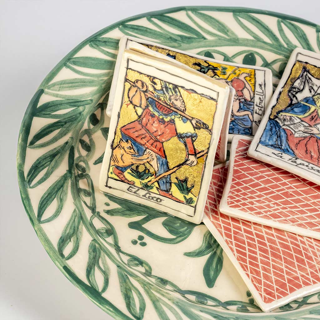 Ceramic still life of a green plate with tarot cards, handmade and painted in a unique style by Spanish artist Maite Morell.