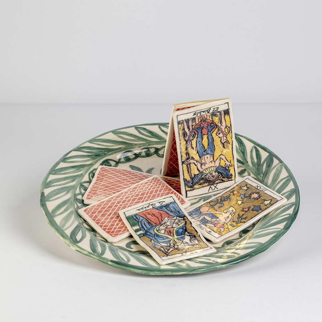 Ceramic still life of a green plate with tarot cards, handmade and painted in a unique style by Spanish artist Maite Morell.