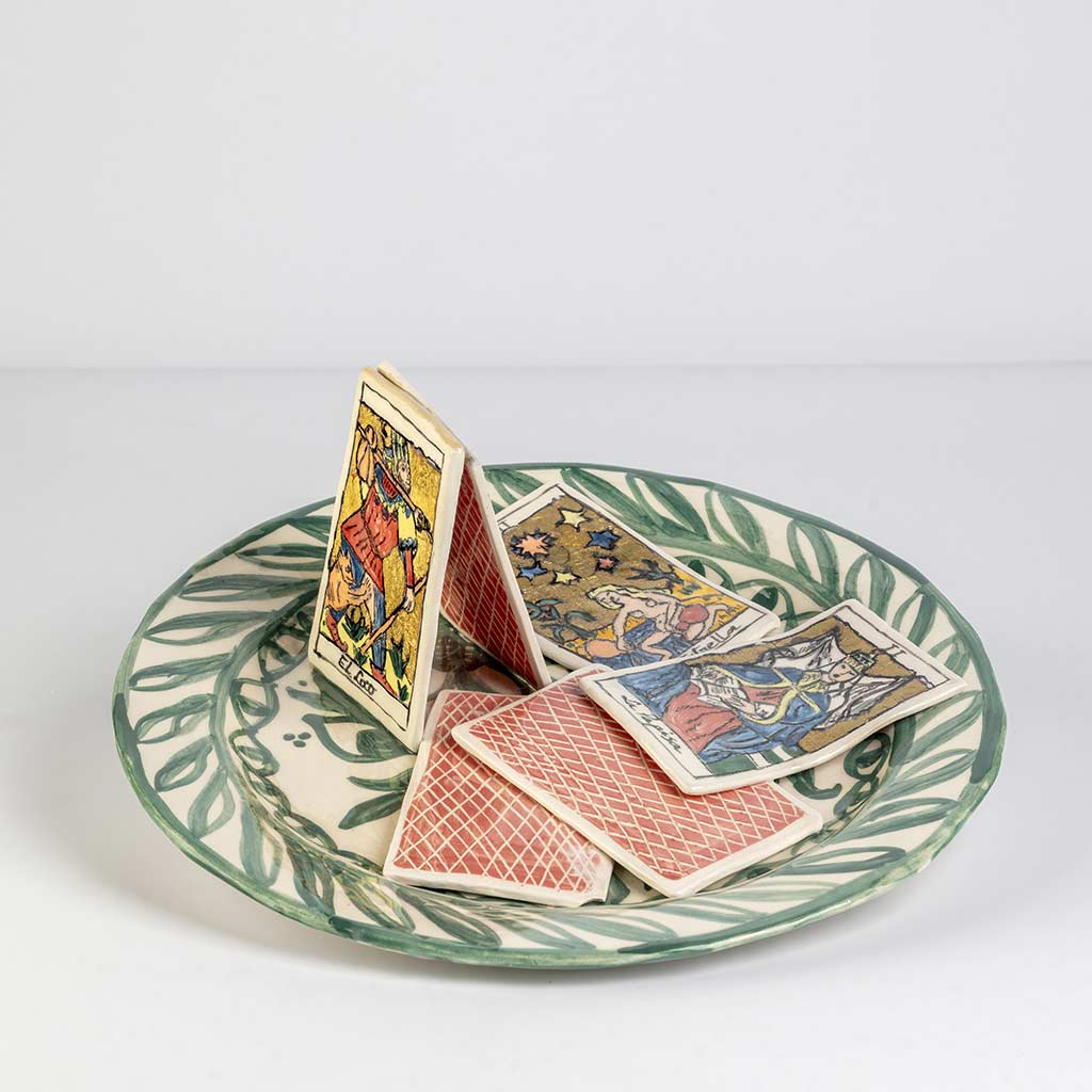 Ceramic still life of a green plate with tarot cards, handmade and painted in a unique style by Spanish artist Maite Morell.