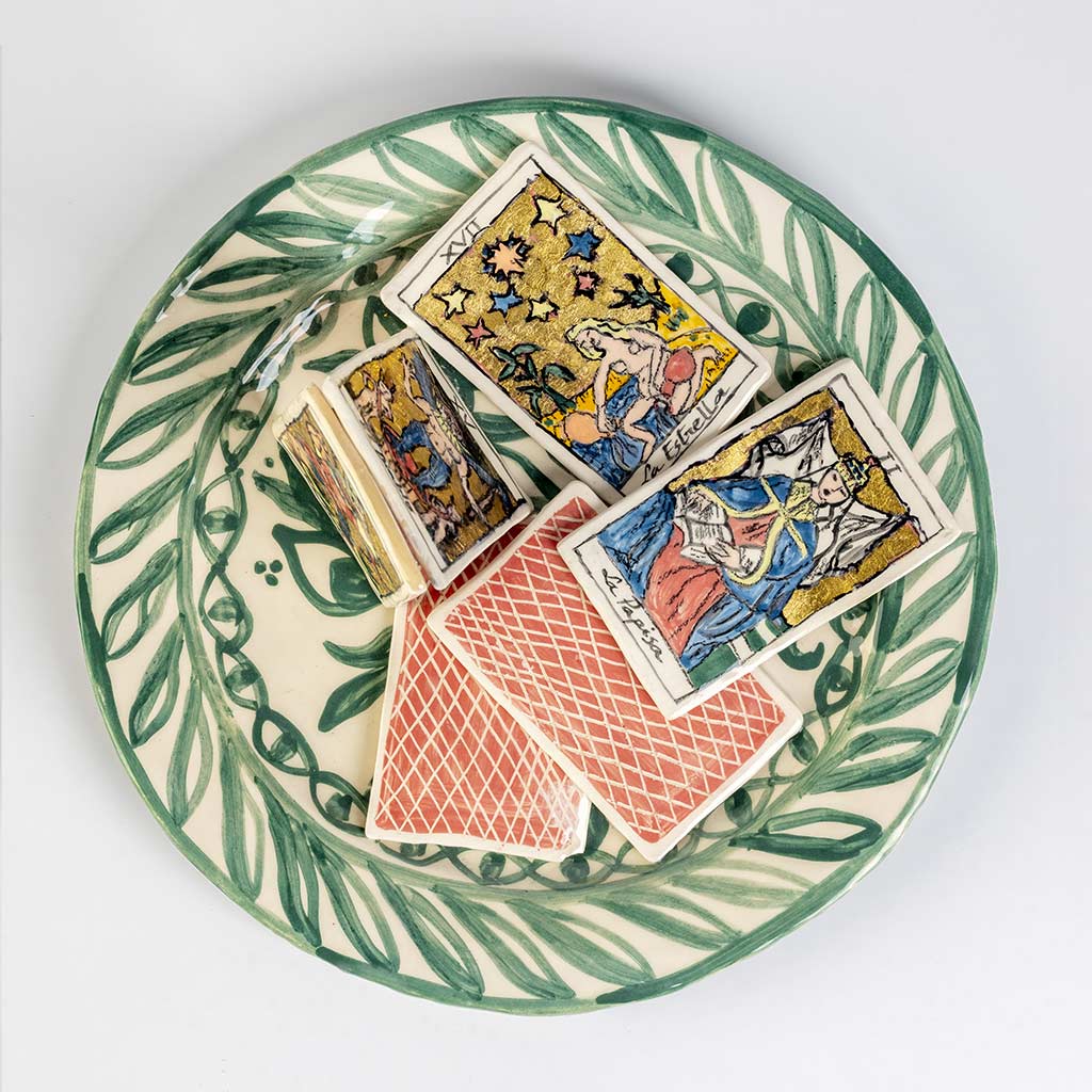 Ceramic still life of a green plate with tarot cards, handmade and painted in a unique style by Spanish artist Maite Morell.