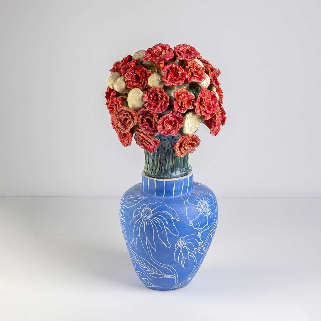 Ceramic still life of a klein blue vase with red carnations, handmade and painted in a unique style by Spanish artist Maite Morell.